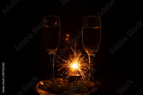 .Silhouettes of champagne glasses with fireworks and grapes for Happy New Year celebration