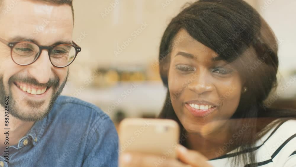 Close up portrait of two beautiful people sitting in cafe. Beautiful woman holding smartphone, man explains how to use device. Close up portrait of two beautiful people sitting in cafe. Beautiful woman holding smartphone, man explains how to use device.