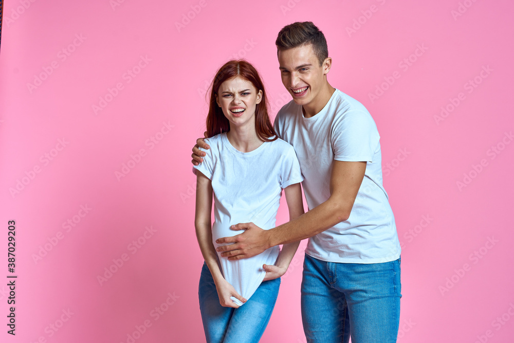 pregnant mom and happy father on pink background Young family waiting for baby pregnant mom and happy father on pink background Young family waiting for baby