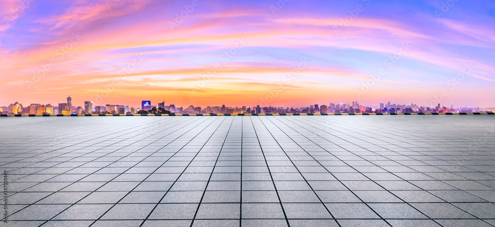 Wide square floor and city skyline with buildings in Hangzhou at sunrise.