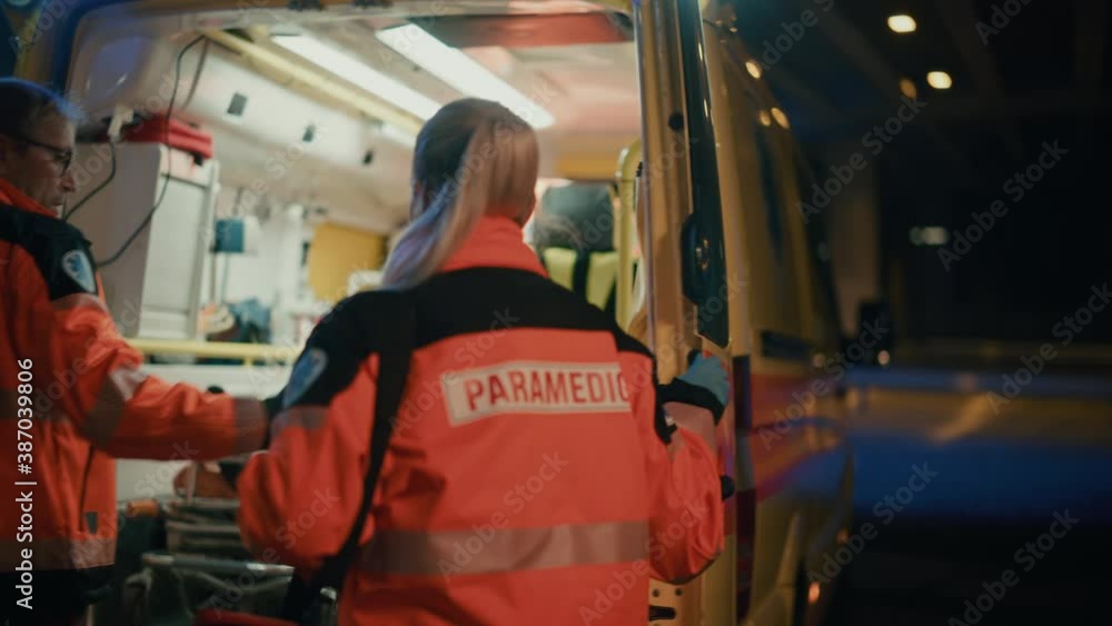 Team of EMS Paramedics React Quick to Provide Medical Help to Injured Patient and Get Him in Ambulance on a Stretcher. Emergency Care Assistants Arrived on the Scene of a Traffic Accident on a Street. Team of EMS Paramedics React Quick to Provide Medical Help to Injured Patient and Get Him in Ambulance on a Stretcher. Emergency Care Assistants Arrived on the Scene of a Traffic Accident on a Street.
