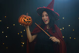 portrait of women in halloween witch costume holding pumpkin for halloween night party