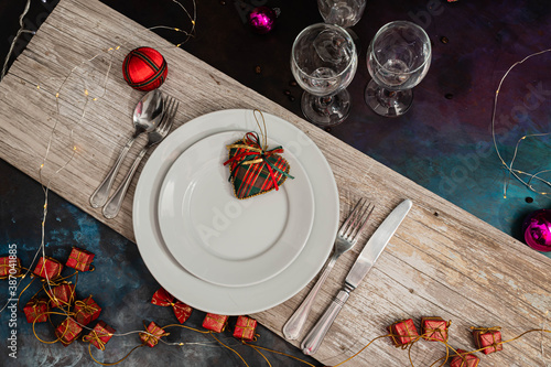 mesa para las fiestas de navidad y año nuevo con plato copa cubierto sobre madera y adornos navideños luces boketh 2020 año nuevo 
 2021 verano hemisferio sur photo