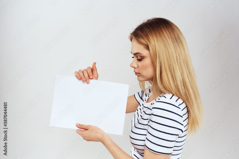 woman holding a sheet of paper in her hands lifestyle striped t-shirt cropped view Copy Space woman holding a sheet of paper in her hands lifestyle striped t-shirt cropped view Copy Space