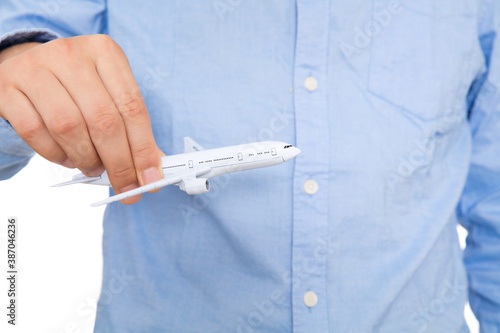 Close-up of man in shirt holding passenger plane model