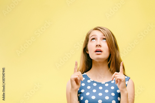 teen girl on yellow background shows thumbs up