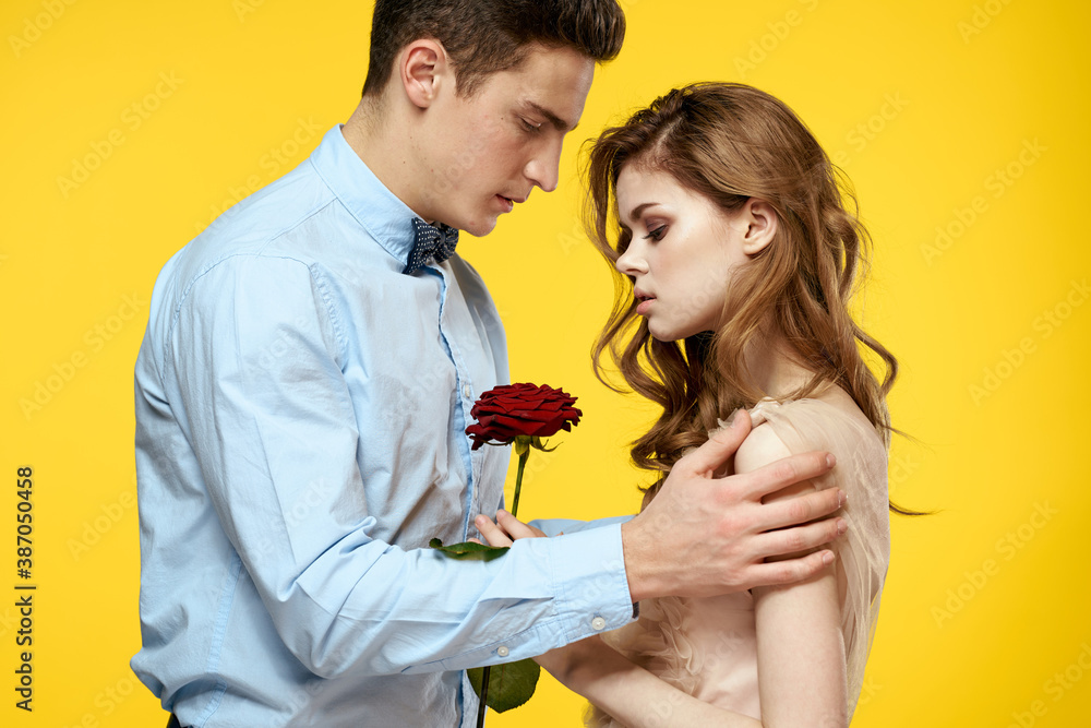 Enamored man and woman with red rose on yellow background cropped view close-up romance Enamored man and woman with red rose on yellow background cropped view close-up romance