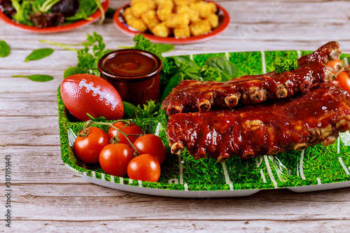 Tangy barbecue spare ribs with tomatoes for football party.