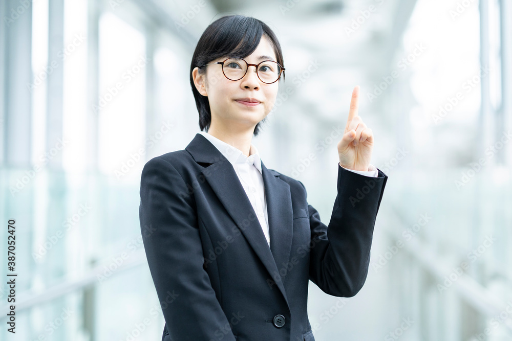 人差し指を立てるポーズをするスーツ姿の若い女性 Stock Photo Adobe Stock 人差し指を立てるポーズをするスーツ姿の若い女性 Stock Photo Adobe Stock