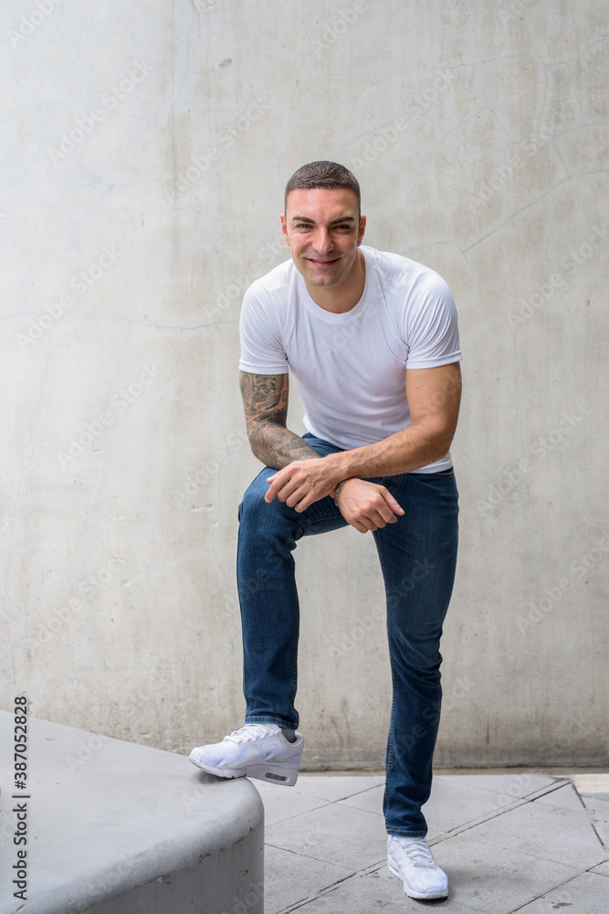 Full body shot of happy handsome man with tattoos smiling Full body shot of happy handsome man with tattoos smiling