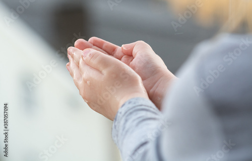 The child catches raindrops with his hands.