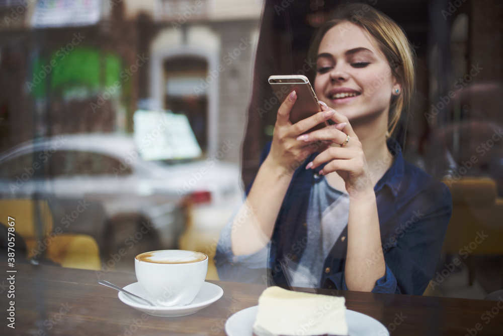 Woman with phone in hands chatting breakfast in a cafe