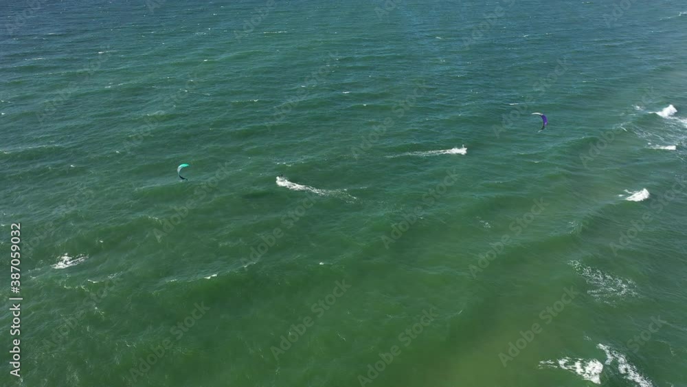 AERIAL: Locked Shot of Surfers in Green Baltic Sea on Perfect Sunny Weather in Natural Daylight AERIAL: Locked Shot of Surfers in Green Baltic Sea on Perfect Sunny Weather in Natural Daylight
