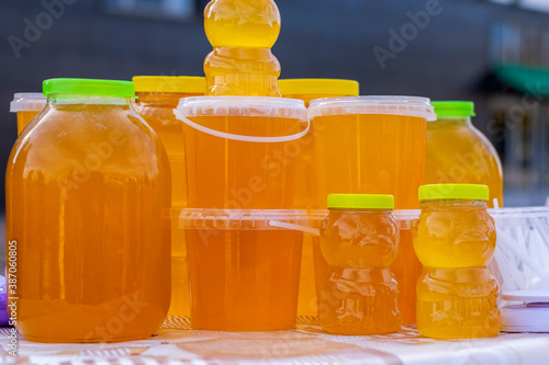 Bashkir bee honey is poured into different containers for sale at the autumn fair.