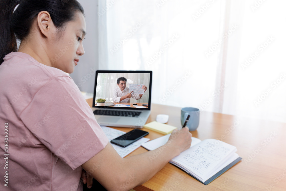 rear angle view of video conference with teacher on laptop at home. Top view businesswomen using laptop meeting with colleagues. Covid-19 work from home.,  e-learning education concept.