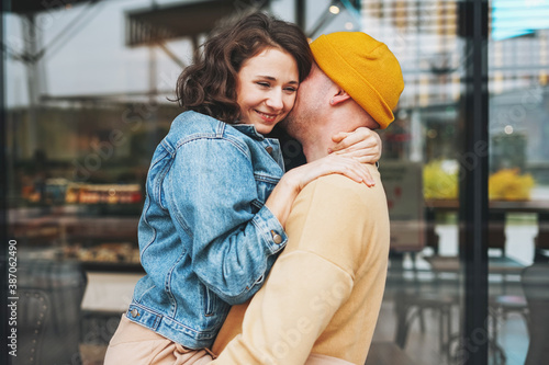 Happy stylish young family couple in love hipsters having fun against the glass wall