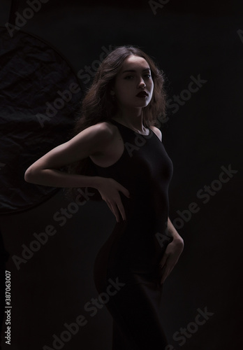 Silhouette of a beautiful, slender brunette in a black dress