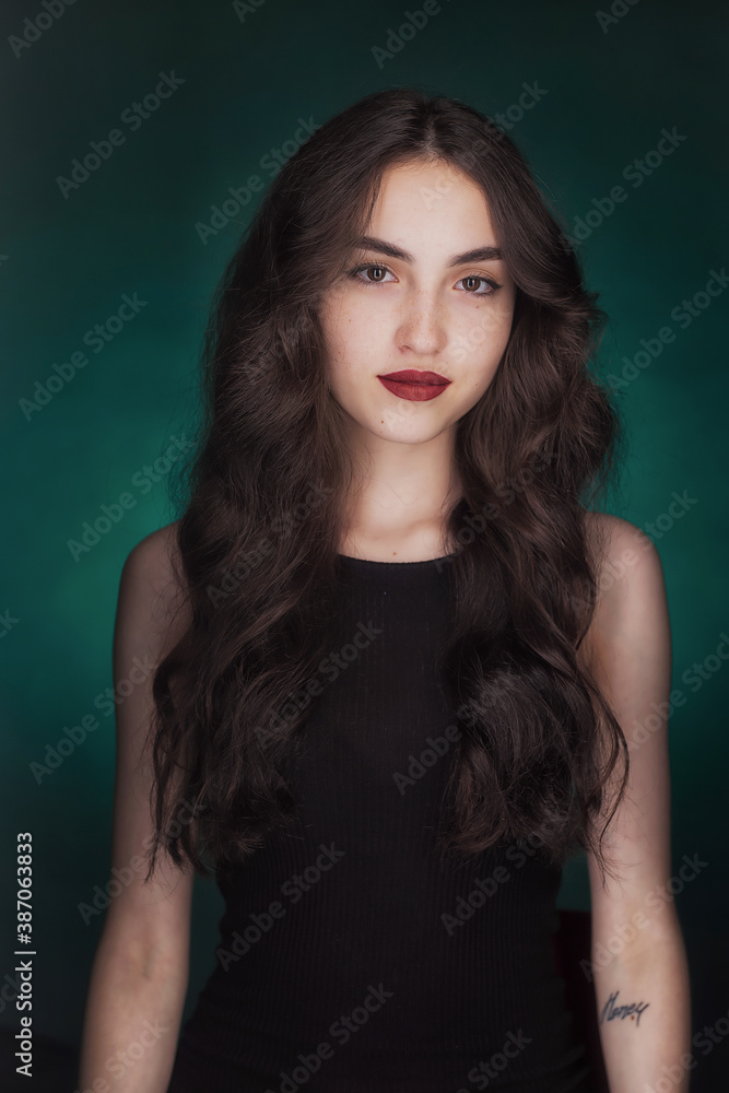 Portrait of a young brunette with lush wavy hair and beautiful highlights in the eyes Portrait of a young brunette with lush wavy hair and beautiful highlights in the eyes