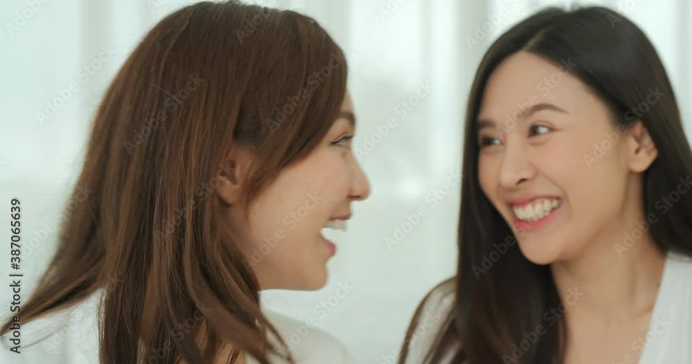 Two young lady talking with funny emotion. She gossip some secret to her friend with smiling at home. Two young lady talking with funny emotion. She gossip some secret to her friend with smiling at home.