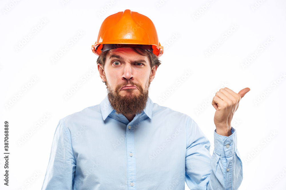 A man gestures with his hands an engineer orange hard hat safety construction
