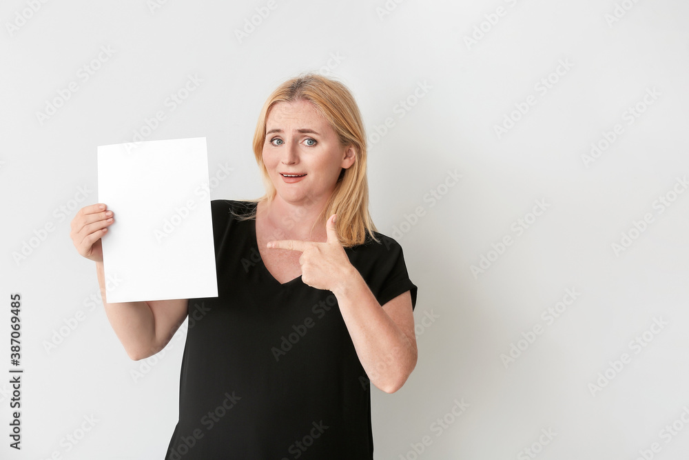 Naklejka premium Woman with blank paper sheet on grey background