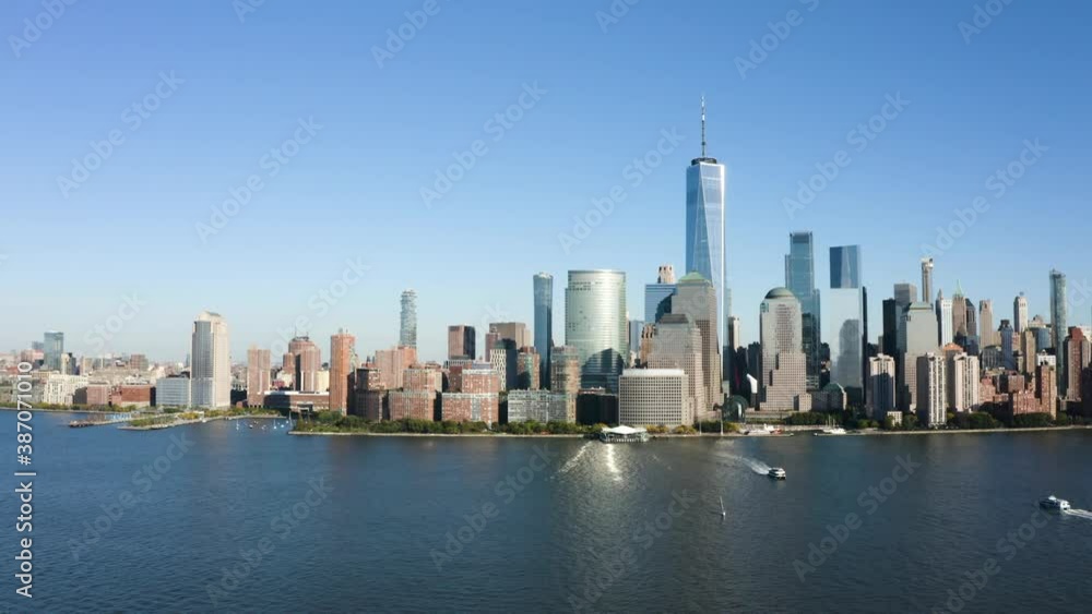 a drone flyby in the afternoon of lower manhattan, ny. the freedom tower prominently shows its height against a clear bright blue sky. a drone flyby in the afternoon of lower manhattan, ny. the freedom tower prominently shows its height against a clear bright blue sky.