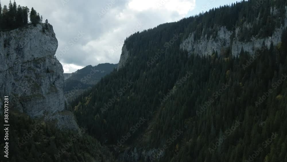 Revealing aerial view of two rocky mountains covered with forest in the cold morning 4K Revealing aerial view of two rocky mountains covered with forest in the cold morning 4K