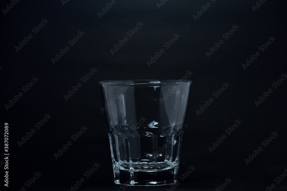 A 100 ml transparent glass on a black background A 100 ml transparent glass on a black background