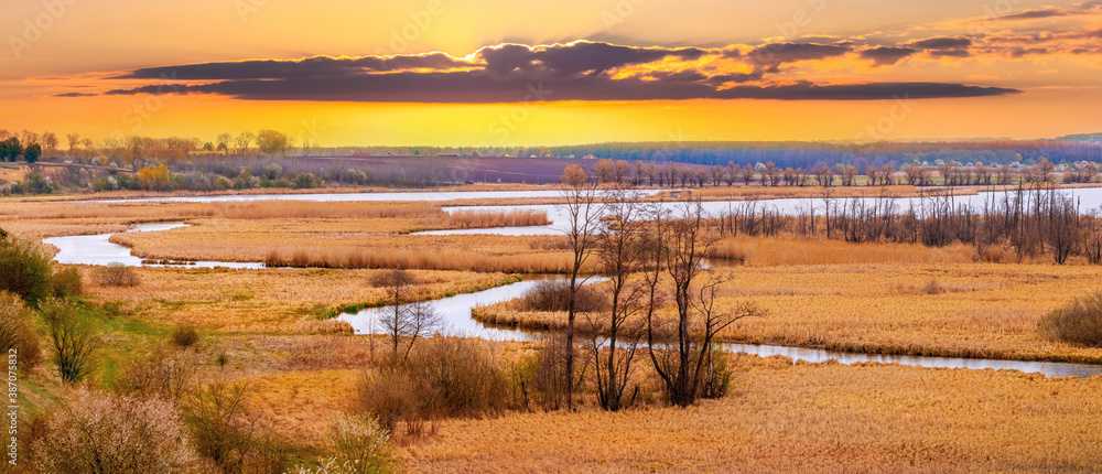 Obraz premium Sunset over a vast plain with a winding river