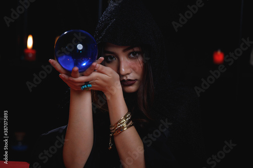 Fortune teller holding blue crystal ball.