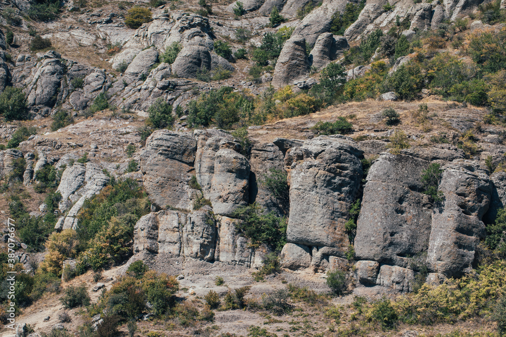 Ridge of brown rocks covered with greenery against a blue sky Ridge of brown rocks covered with greenery against a blue sky