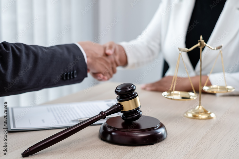 shake hand Professional male lawyers work at a law office There are scales, Scales of justice, judges gavel, and litigation documents. Concepts of law and justice shake hand Professional male lawyers work at a law office There are scales, Scales of justice, judges gavel, and litigation documents. Concepts of law and justice