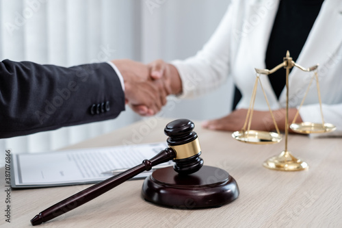 shake hand Professional male lawyers work at a law office There are scales, Scales of justice, judges gavel, and litigation documents. Concepts of law and justice