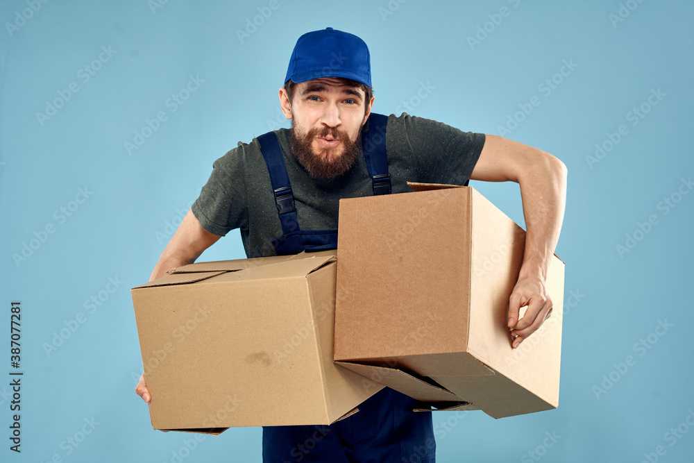 working man boxes in hands delivery service packaging lifestyle blue background working man boxes in hands delivery service packaging lifestyle blue background