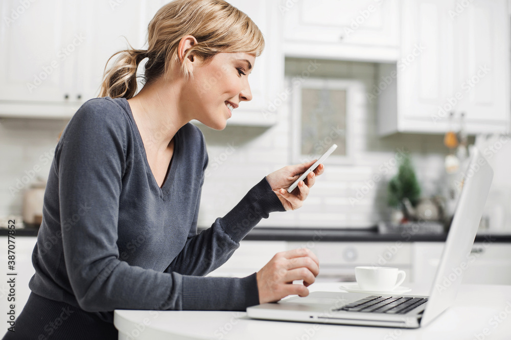 Young woman using laptop and smartphone at home, girl working on computer indoors, Freelance, student lifestyle, distance education, work or studying from home, technology and online shopping concept Young woman using laptop and smartphone at home, girl working on computer indoors, Freelance, student lifestyle, distance education, work or studying from home, technology and online shopping concept