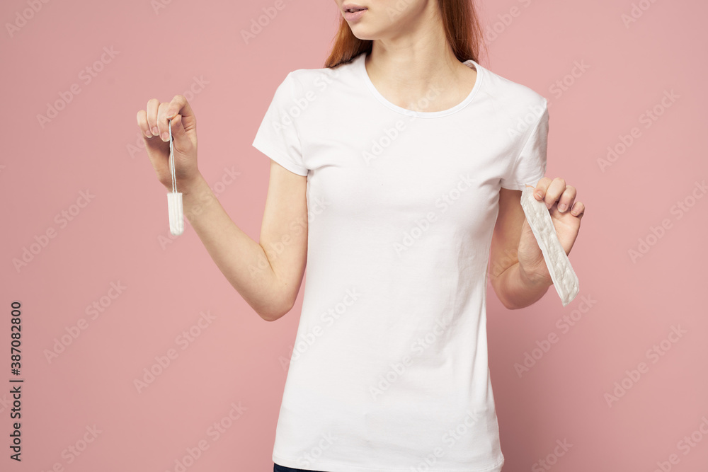 Girl with a pad and tampons in hand pink background menstruation critical days hygiene Girl with a pad and tampons in hand pink background menstruation critical days hygiene