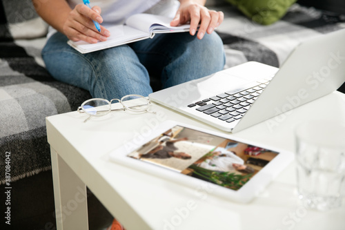 Meeting online, education. Remote working from home. Workplace in home office on sofa with laptop and devices. Concept of distance learning, isolation, female business, shopping online, conference.