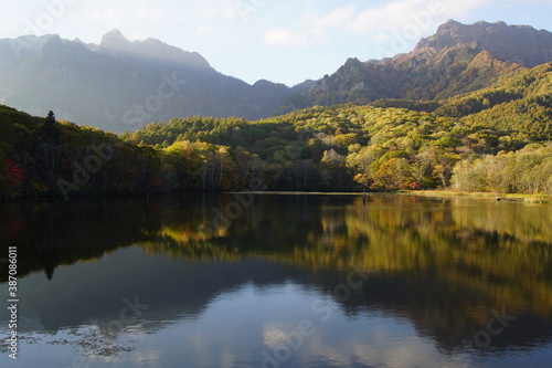 Fototapeta Naklejka Na Ścianę i Meble -  A pond that reflects trees and mountains like a mirror. At dusk. Beautiful scenery of Japan.