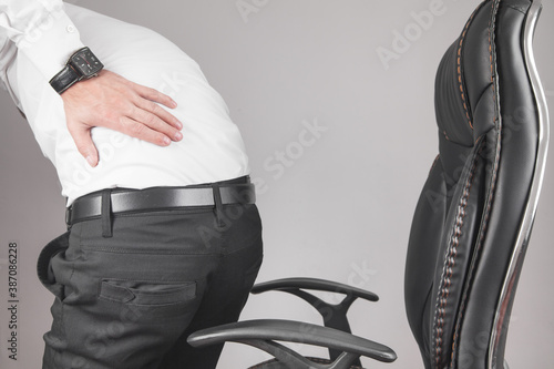 Caucasian businessman suffering from back pain in office.