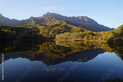 A pond that reflects trees and mountains like a mirror. At dusk. Beautiful scenery of Japan. © Hirotsugu