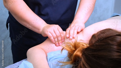 The massage therapist performs anti-cellulite massage of the body of a fat woman. Overweight treatment.