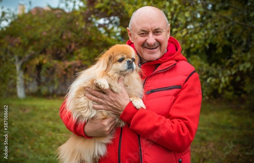 Senior man with a red little dog outdoor, man retired, lifestyle of older people