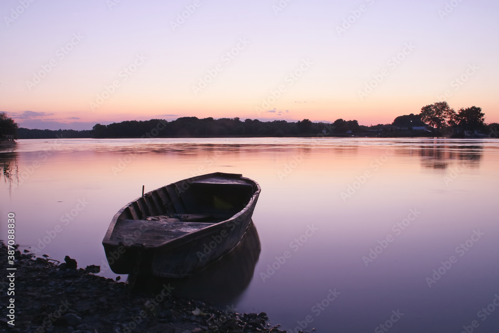 Una vieja barca de remos amarrada al atardecer en el delta del Danubio, Rumanía. Atardecer en la desembocadura del río Danubio en el pueblo de Nufaru.