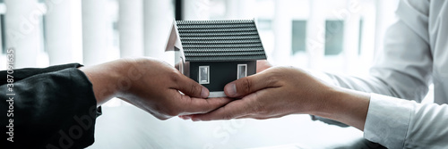 Принти на полотні Sale Estate agent giving house model to new client after signing agreement contr