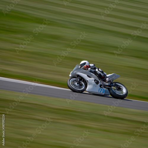 A panning shot of a racing bike cornering on a track. © SnapstitchPhoto