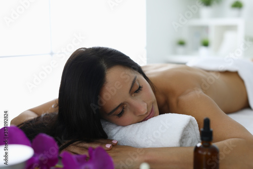 Woman with closed eyes lies in spa center and rests. Complex services in beauty salons concept