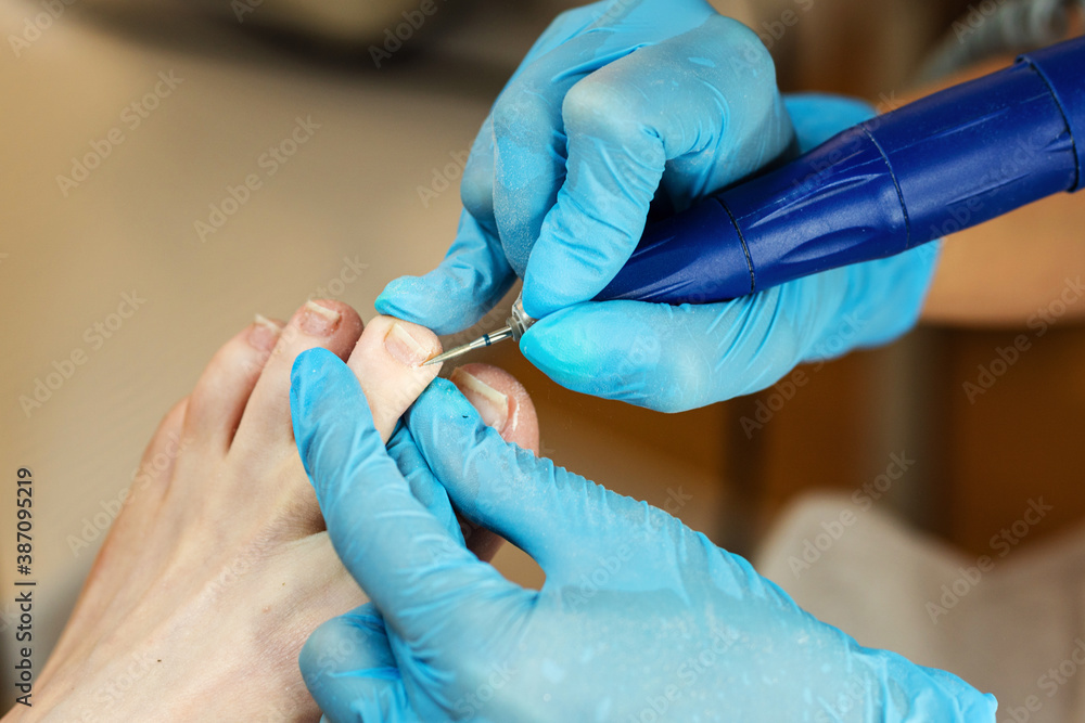 Hardware pedicure, preparation of the nail plate for applying gel polish. Master chiropody