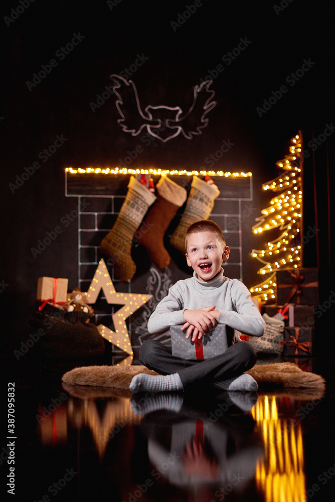 Happy boy holding a gift for the new year Happy boy holding a gift for the new year