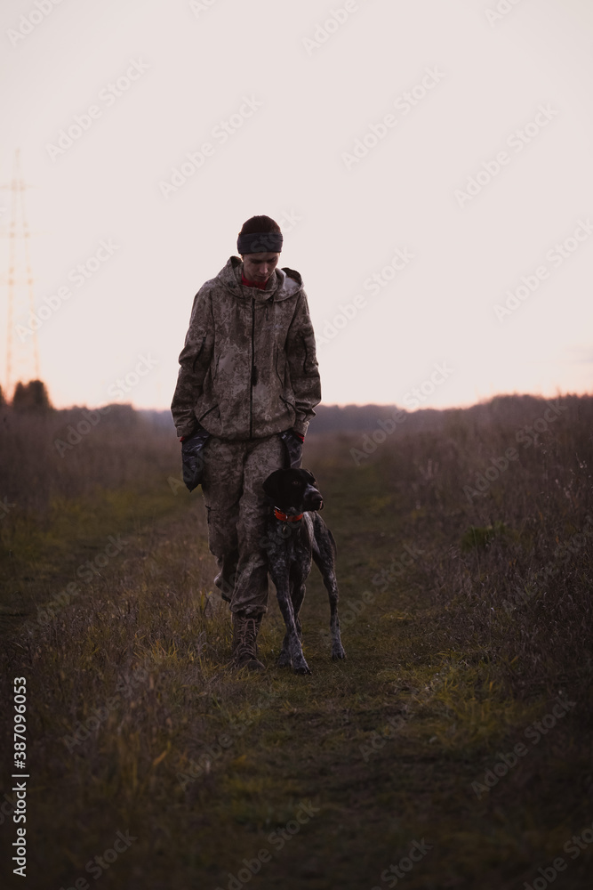 Girl in camouflage with hunting dog