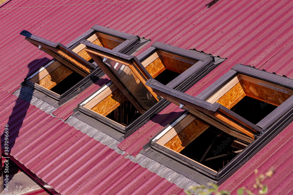 Opened roof windows. Skylight on red ceramic house tiles. Skylights ...